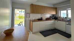 Une cuisine moderne avec des meubles en bois, un plan de travail noir et une vue sur l’extérieur.