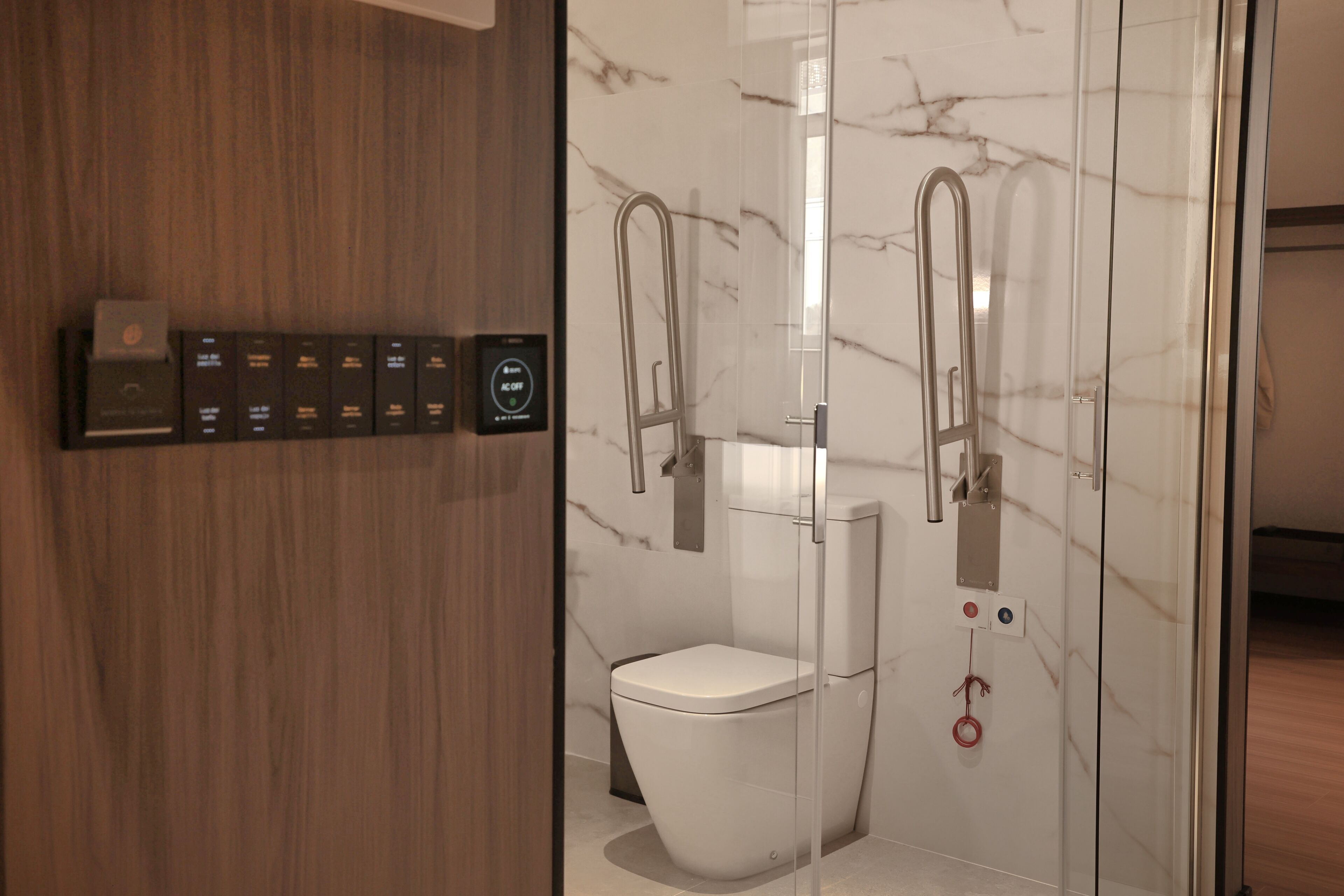 A modern bathroom with a toilet, bidet, and glass shower enclosure.