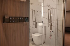 A modern bathroom with a toilet, bidet, and glass shower enclosure. - HOTEL HUALTON (Alcobendas)