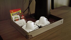 Una bandeja con una cafetera, dos tazas y una caja de café instantáneo Nescafé.