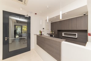 A modern kitchen with a dark wood countertop, a glass door, and a view of the outdoors. - Altiora Prestige Residence 301 (Gradac)