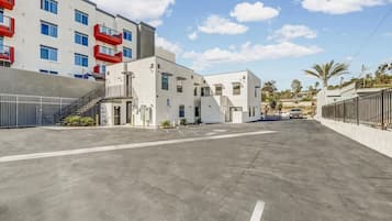 A multi-story building with a parking lot in front.