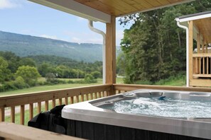 A hot tub on a wooden deck with a view of a forest and mountains. - 3 Cabins, Sleeps 18 - Private Hot Tubs, Near Chatt (Chattanooga)