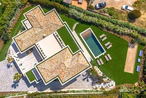 An aerial view of a property with multiple roofed terraces, a swimming pool, and a well-maintained lawn. - Superb villa with swimming pool in a secure estate close to the beach and town center (Sainte-Maxime)