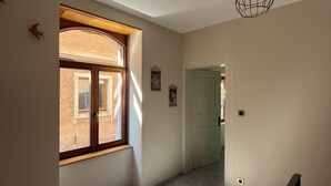 A hallway with a large window, a door, and a ceiling light fixture. - Gîte de la Rivière, 3 stars, sleeps 2 to 6, Munster, Colmar, wine routes, and mountain ridges (Breitenbach-Haut-Rhin)
