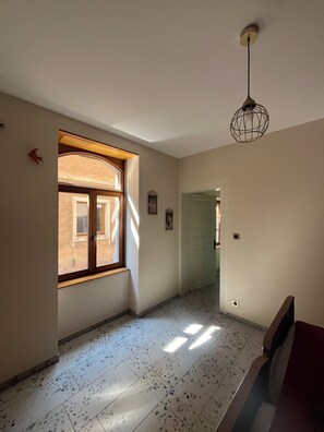 A hallway with a large window, a door, and a ceiling light fixture. - Gîte de la Rivière, 3 stars, sleeps 2 to 6, Munster, Colmar, wine routes, and mountain ridges (Breitenbach-Haut-Rhin)