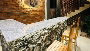 A modern bar area with a stone wall, a sign for 'Airport Hotel Transit 98,' and a staircase. - Airport Hotel Transit 98  (Katunayake)