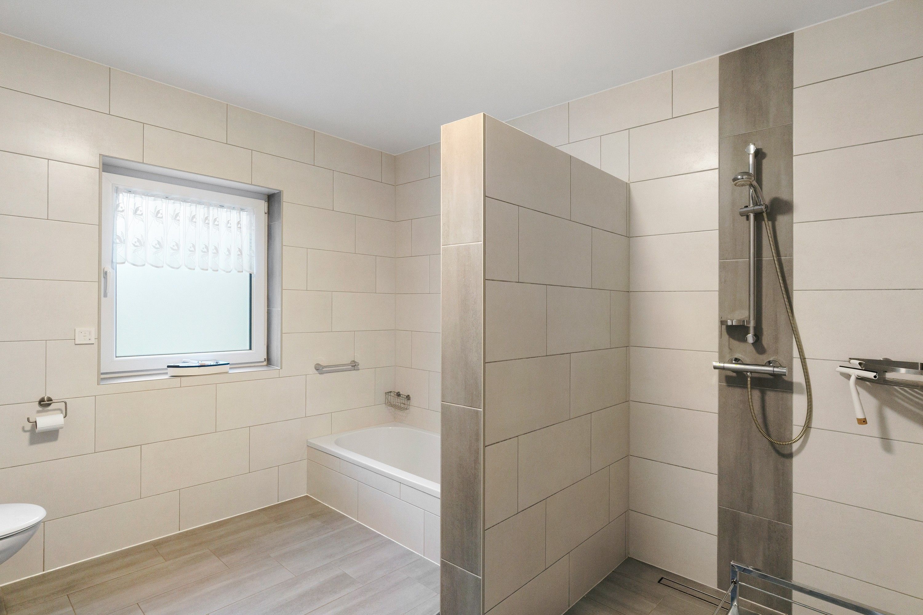 Ein modernes Badezimmer mit Dusche, Toilette und Badewanne.