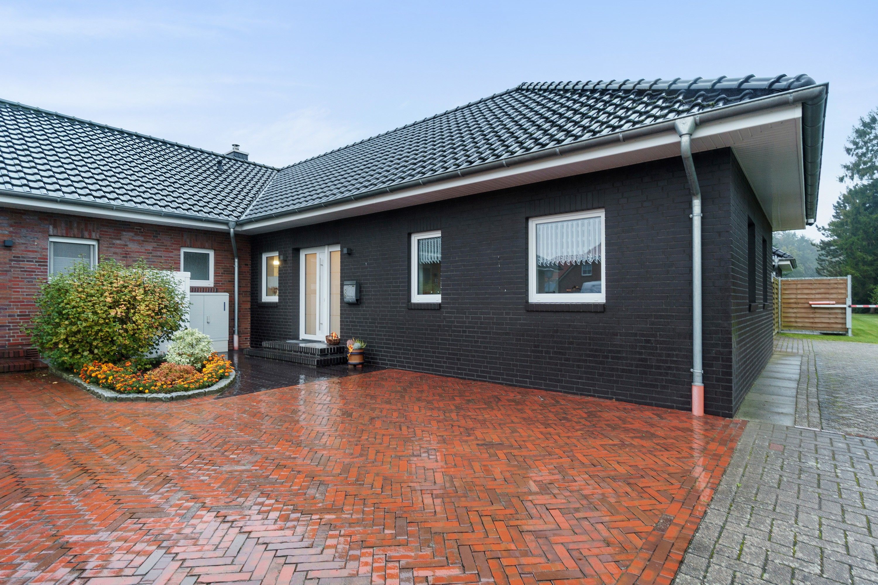 Ein zweigeschossiges Haus mit Ziegelaußenwand und einem Ziegeldach.