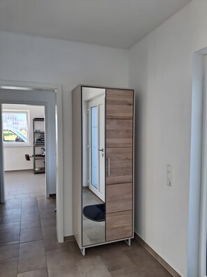 A room with a wardrobe, a door leading to another room, and a view of a building outside. - Apartment 'Kleine Schwalbe' with Private Terrace and Wi-Fi (Rechtsupweg)