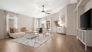 Ein stilvolles Wohnzimmer mit Sofa, Couchtisch und Fernsehschrank.
