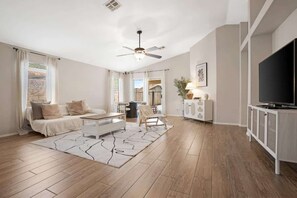 A modern living room with a sofa, coffee table, and TV stand.