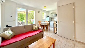 A compact living space with a sofa, a dining table, and a kitchenette. - La cachette du mas, 4 guests, Pool in Calvisson (Calvisson)