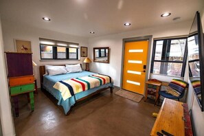 A bedroom with a bed, a desk, a chair, a window, and a door. - NEW! Library House! AC/Grill/Near downtown. (Flagstaff)