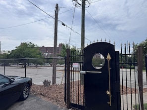 A gated entrance with a black gate, a chain-link fence, and a building in the background. - Relaxing Renegade - 2 bedroom 1 bath condo within walking distance to FSU (Tallahassee)