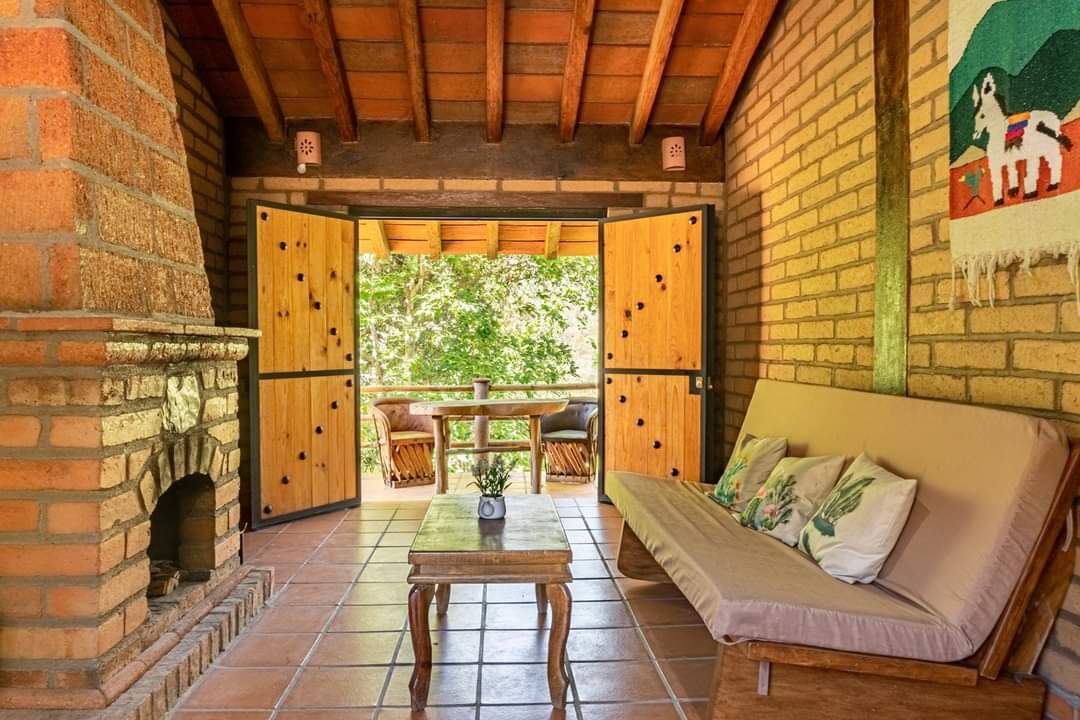 Una habitación acogedora con chimenea de ladrillo, muebles de madera y vistas al exterior.
