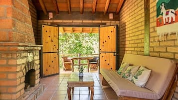 Una habitación acogedora con chimenea de ladrillo, muebles de madera y vistas al exterior.