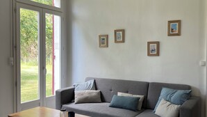 En moderne stue med en grå sofa, et træbord og en hængende lampe.