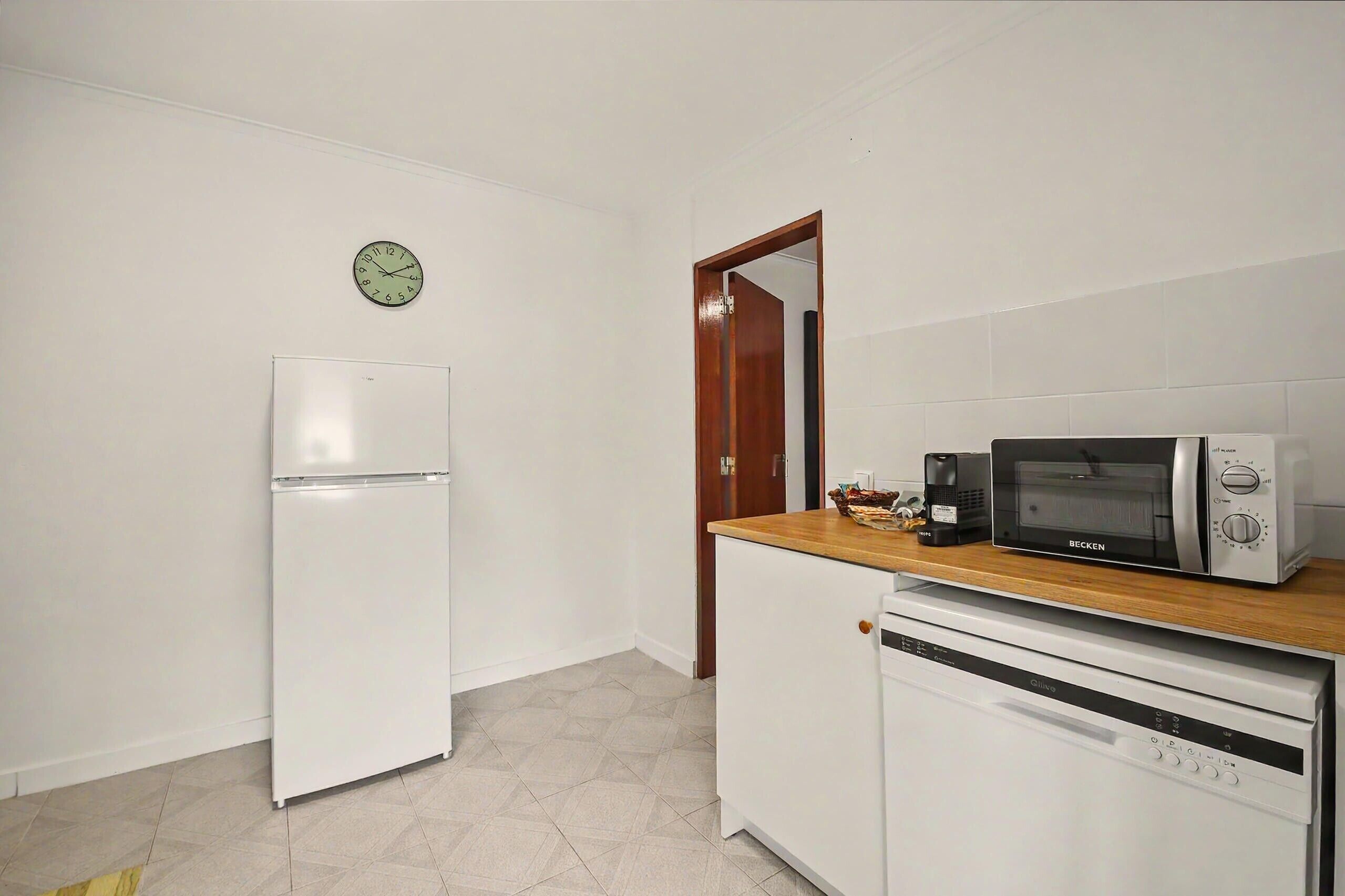 A kitchen with a white refrigerator, a microwave, and a dishwasher.