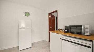 A kitchen with a white refrigerator, a microwave, and a dishwasher.