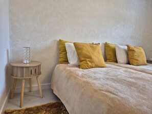 Ein Schlafzimmer mit einem Bett, einem Nachttisch und einer Lampe.