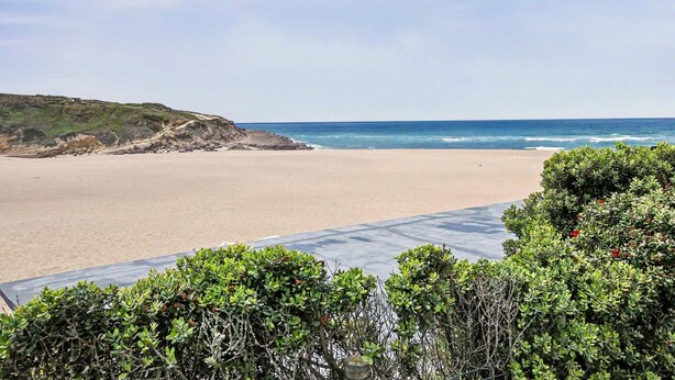 Ein Strand mit freiem Blick auf den Ozean und einem Sandstrand.