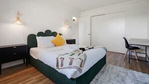A bedroom with a bed, bedside tables, a desk, and a chair. - -Cozy 2-Bedroom Retreat in Pacifica (Pacifica)