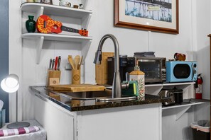 A kitchen with a sink, countertop, and various appliances including a microwave and toaster. - Gardenia Studio: Hilo Oasis w/ AC | Walk to Shops (Hilo)