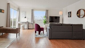 A living room with a sofa, a chair, a TV, and a desk with a computer. - +Tranquil 2BR with Coastal and Mountain Views (Pacifica)