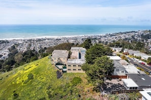 A residential area with a hillside, a road, and a view of the ocean. - -Stunning 2BR w/Ocean, Mountain & Sunset Views (Pacifica)