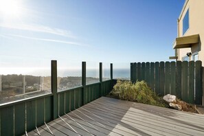 Ein Balkon mit Blick auf den Ozean und einer Holzterrasse.
