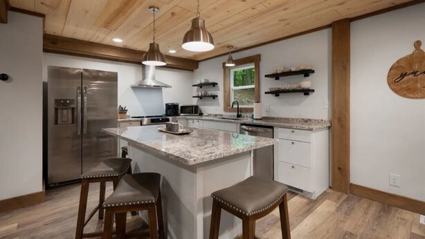 A modern kitchen with a central island, stainless steel appliances, and wooden accents. - Your Modern Creekside Retreat with Resort Perks! Modern 2bdrm + Open LoftTrundle (Ellijay)