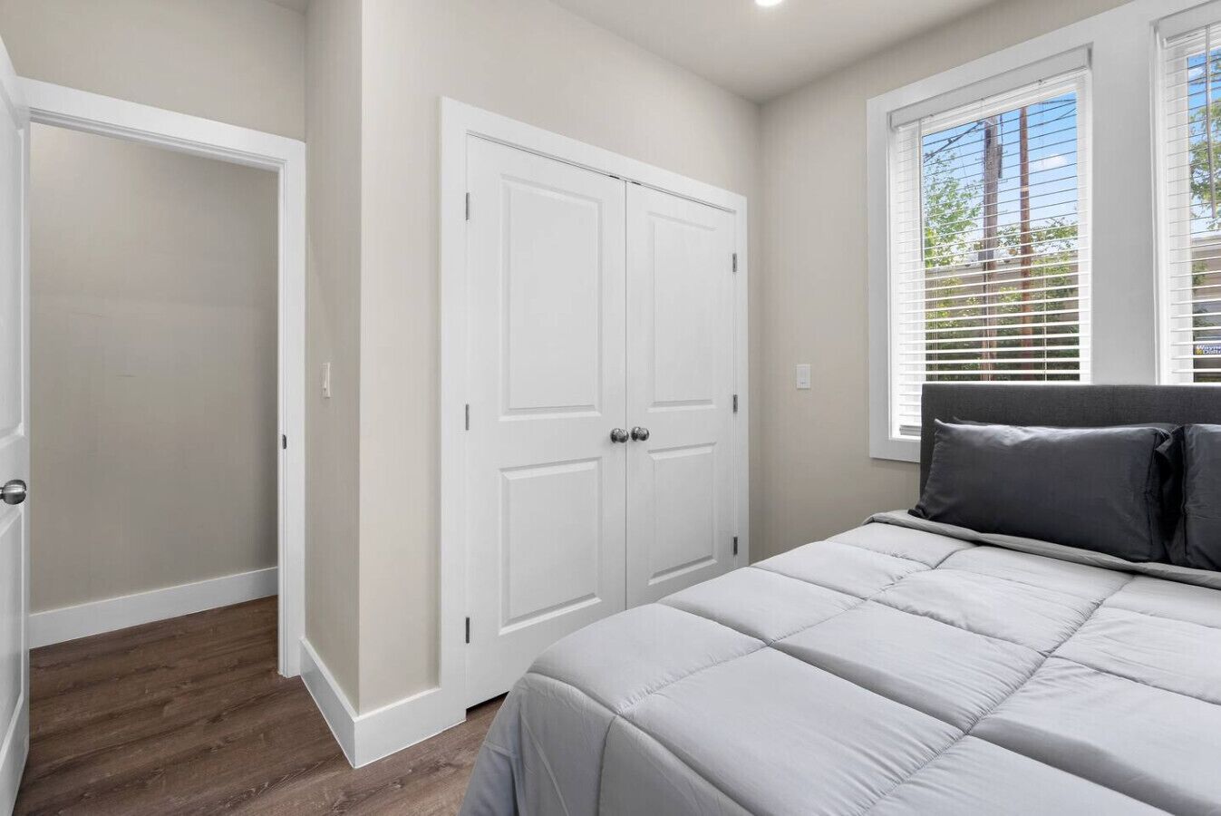 Une chambre à coucher avec un lit, une armoire et une fenêtre équipée de stores.