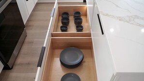 Un cajón de cocina con platos y cuencos negros.