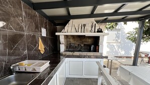 Una cocina con protector de piedra, horno empotrado y fregadero.