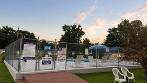 A fenced pool area with a wooden deck, lounge chairs, and various signs indicating pool rules and no smoking. - BEACHWAY MOTEL (Salisbury)