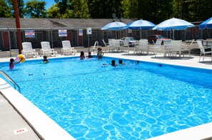 A swimming pool with a fenced area, lounge chairs, and umbrellas. - BEACHWAY MOTEL (Salisbury)