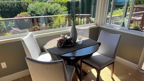 A sunlit room with a table and two chairs, a vase, and a glass on the table. - 3-bedroom house in Happy Valley with AC (Happy Valley)