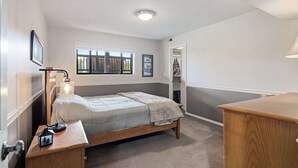 A bedroom with a bed, bedside table, lamp, and a window. - 3-bedroom house in Happy Valley with AC (Happy Valley)