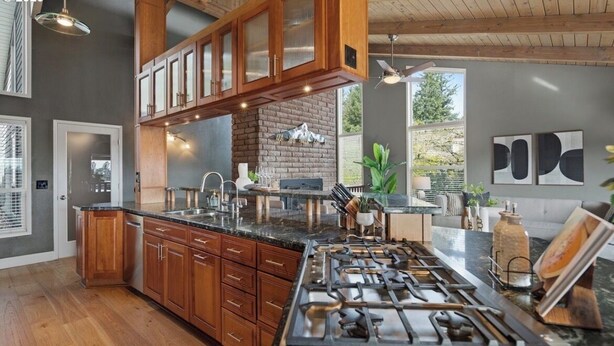 A kitchen with wooden cabinets, a gas stove, and a granite countertop. - 3-bedroom house in Happy Valley with AC (Happy Valley)