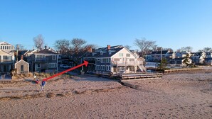 A beachfront property with a large house, a wooden pier, and a sandy beach. - .3 Miles from MacMillan Pier with Parking! (Provincetown)