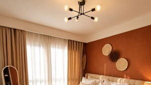 A bedroom with a large bed, a bedside table with a lamp, a chair, and a mirror. - 1 bedroom syokimau near airport with Nairobi national park view. (Nairobi)