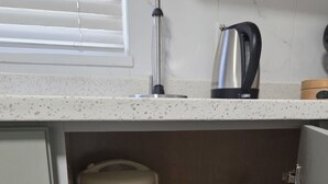 Eine Küche mit Arbeitsplatte, Wasserkocher und Reiskocher.