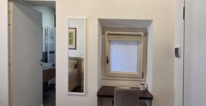 A small room with a window, a mirror, a towel, and a desk. - Ancient Convent - Casoni House (Recanati)