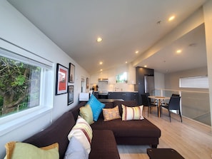 A modern living room with a sofa, a dining area, and a kitchen. - 3BR house near BC Place, Downtown Vancouver FIFA action! Peaceful & independent. (Vancouver)