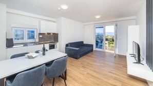 Una cocina moderna con comedor, sofá y televisor.