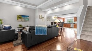 Ein modernes Wohnzimmer mit einer Couch, einem Couchtisch und einem Gemälde an der Wand.