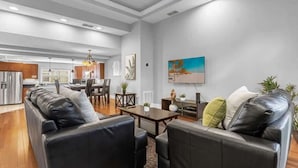 A modern living room with a sofa, coffee table, and dining area.
