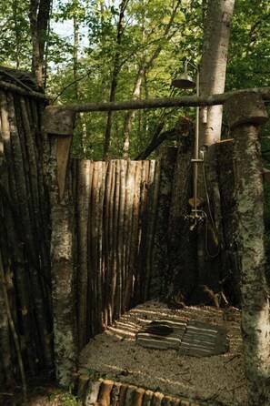 Una estructura rústica de madera con una campana de metal y una escalera.