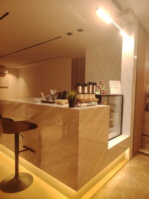 A modern kitchen with a marble countertop, a coffee station, and a bar area. - Rama Dubai Serviced Apartments Hafsa (Riyadh)